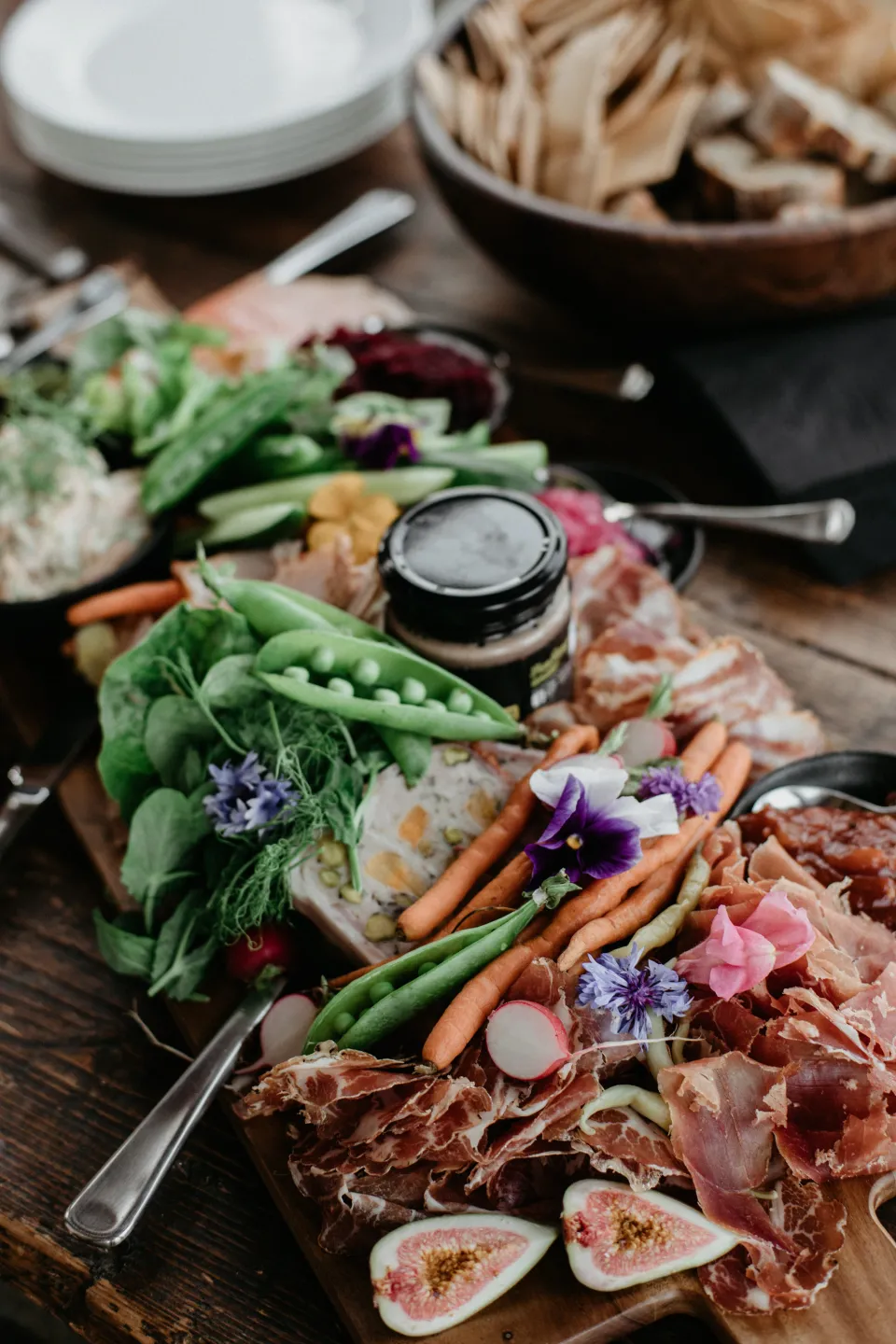 A grazing board with fruit, vegetables, dips and cheeses on a table, at Thalia Haven on the East Coast of Tasmania, Australia, for an Elopement Collective elopement. Photograph by Joey Willis.