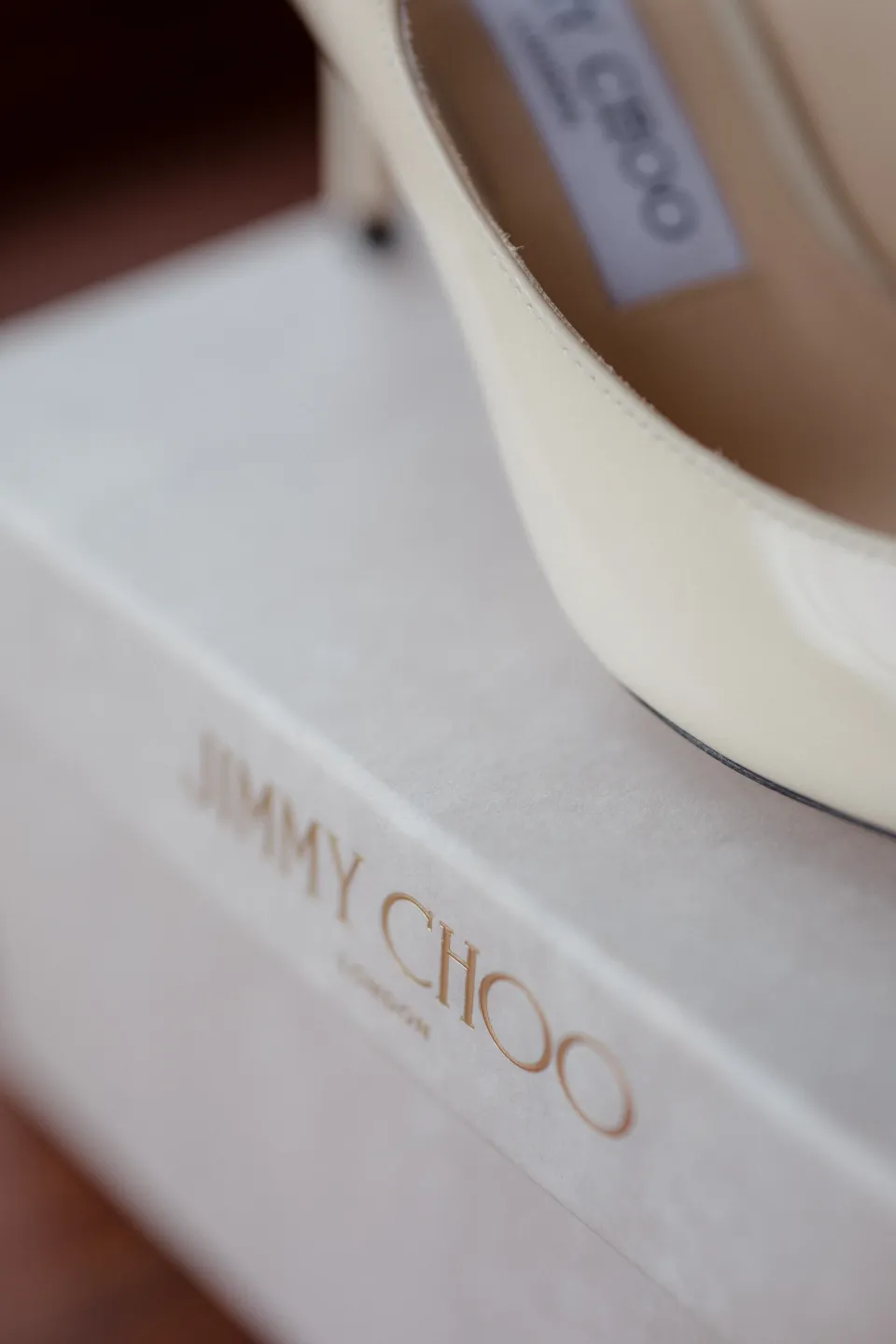 A close view of a white bridal shoe and a Jimmy Choo box, at Thalia Haven on the East Coast of Tasmania, Australia, for an Elopement Collective elopement. Photograph by Joey Willis.