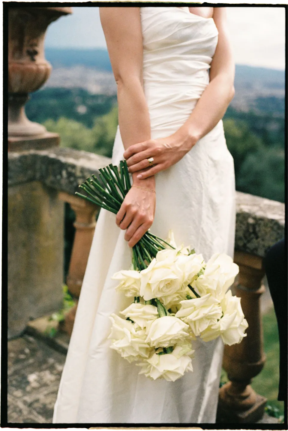 Holly’s hands and white bouquet by Le Francesche Flower Designers against the folds of her wedding dress, at Villa San Michele in Fiesole above Florence, Tuscany, Italy, for an Elopement Collective elopement. Film photograph by Khara from House of Lucie.
