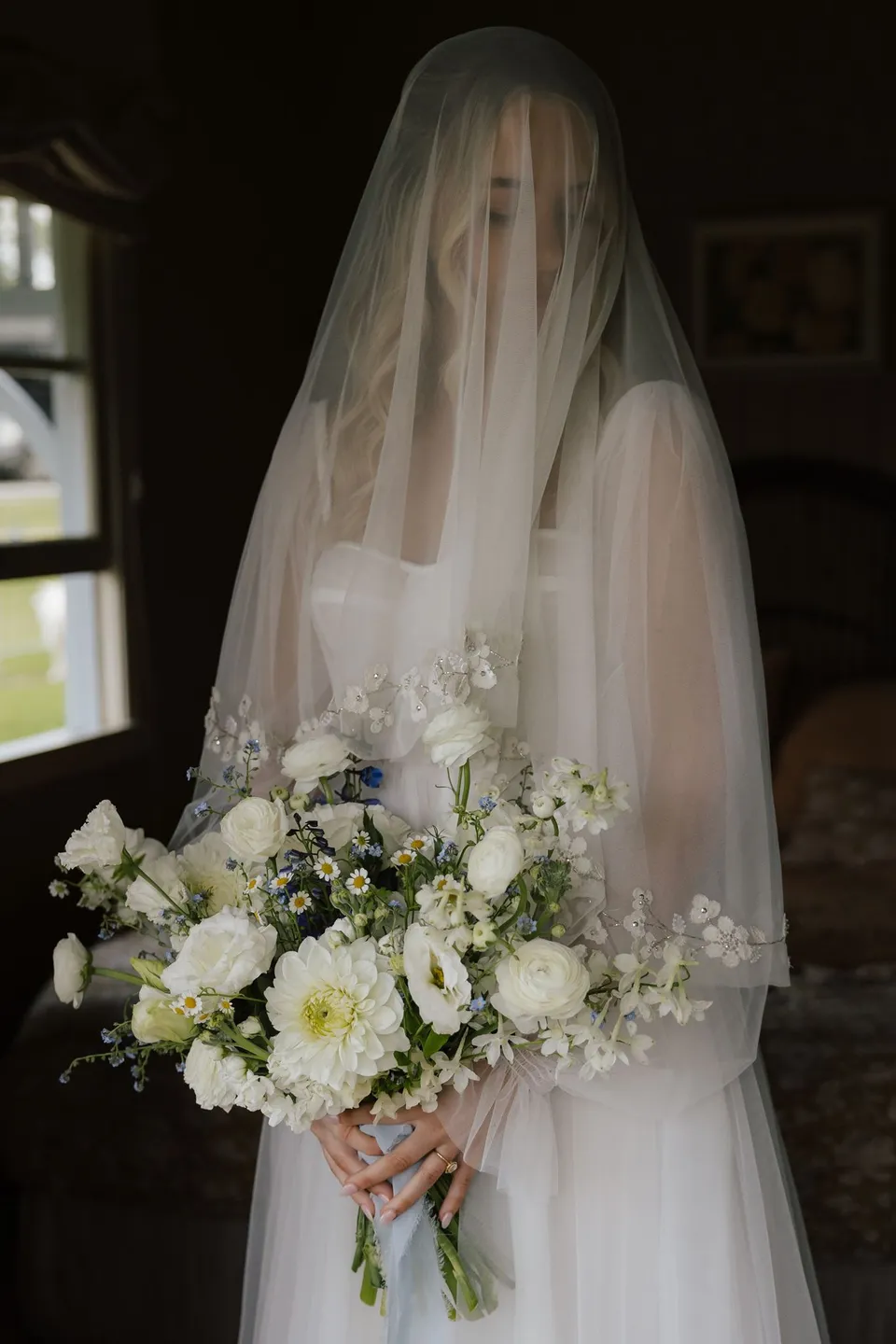 Bridget standing beneath her veil with her white and green bouquet. At Cudgera Creek in northern New South Wales, for an Elopement Collective elopement. Photograph by Bulb Creative.