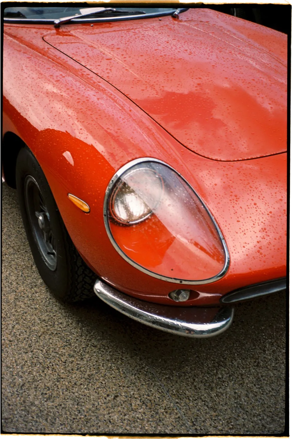 Raindrops on the bonnet and headlight of a red vintage sports car in the villa courtyard, at Villa San Michele in Fiesole above Florence, Tuscany, Italy, for an Elopement Collective elopement. Film photograph by Khara from House of Lucie.