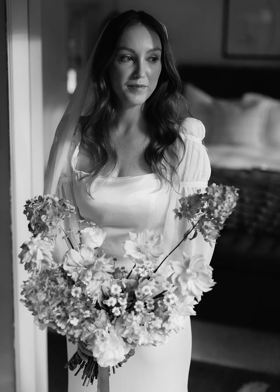 Black-and-white portrait of Elyse with her bouquet and veil, with flowers by The Perfect Party Co. At Fig Tree Villa in Ewingsdale, Byron Bay, for an Elopement Collective elopement. Photograph by Bulb Creative.