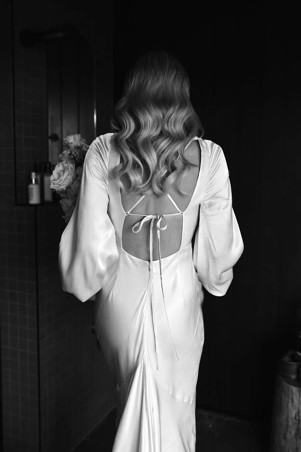 Black and white portrait of Gabrielle’s loose waves and open-back dress inside the cabin at Roundhill Retreat in Obi Obi, Sunshine Coast Hinterland, for their Elopement Collective elopement.