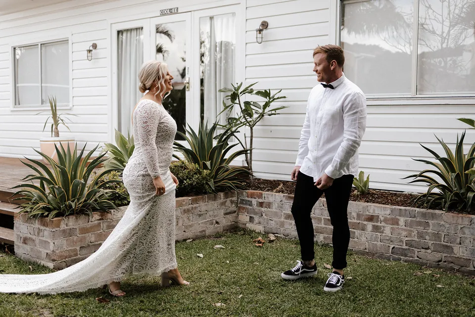 Matt and Laura facing each other in the garden after their first look, at Grounds of Cabarita in Cabarita Beach, NSW, for an Elopement Collective elopement. Photo by Bulb Creative.