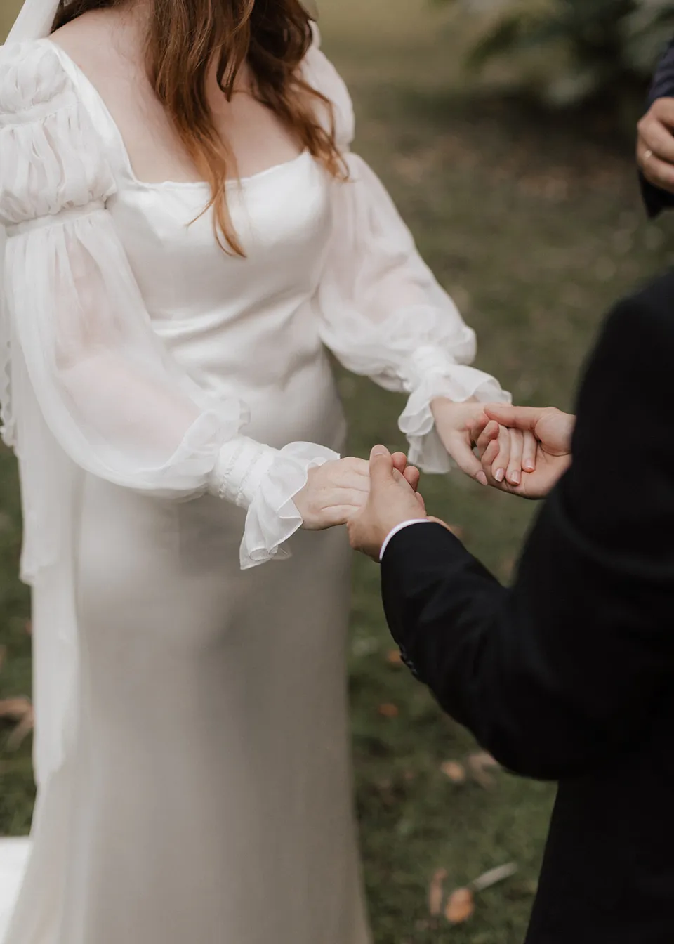Close-up of Elyse and Jonathan holding hands during their ceremony. At Fig Tree Villa in Ewingsdale, Byron Bay, for an Elopement Collective elopement. Photograph by Bulb Creative.