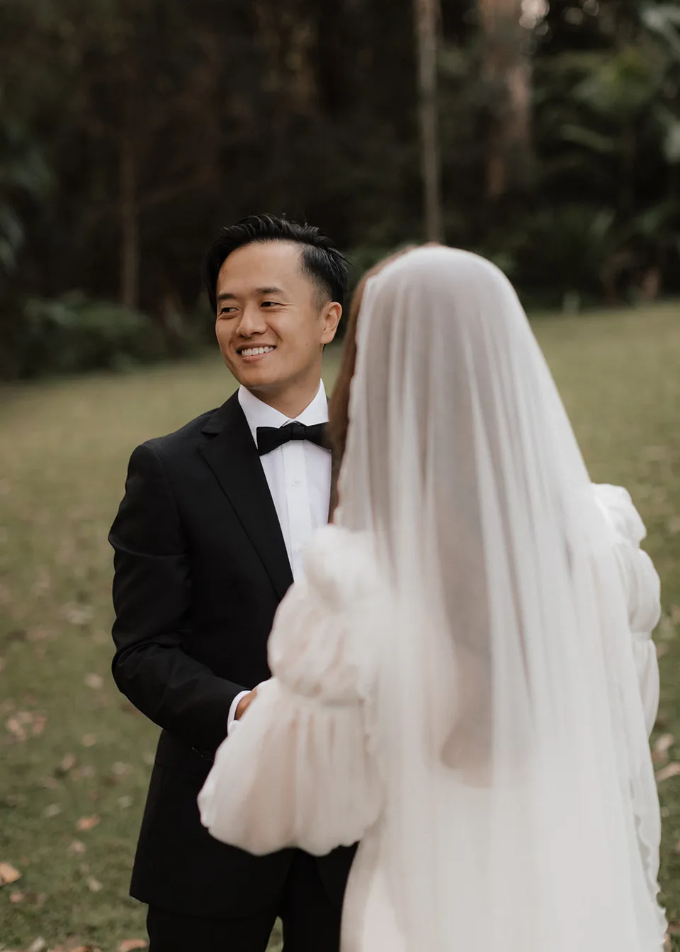 Jonathan laughing with Elyse during their vows. At Fig Tree Villa in Ewingsdale, Byron Bay, for an Elopement Collective elopement. Photograph by Bulb Creative.