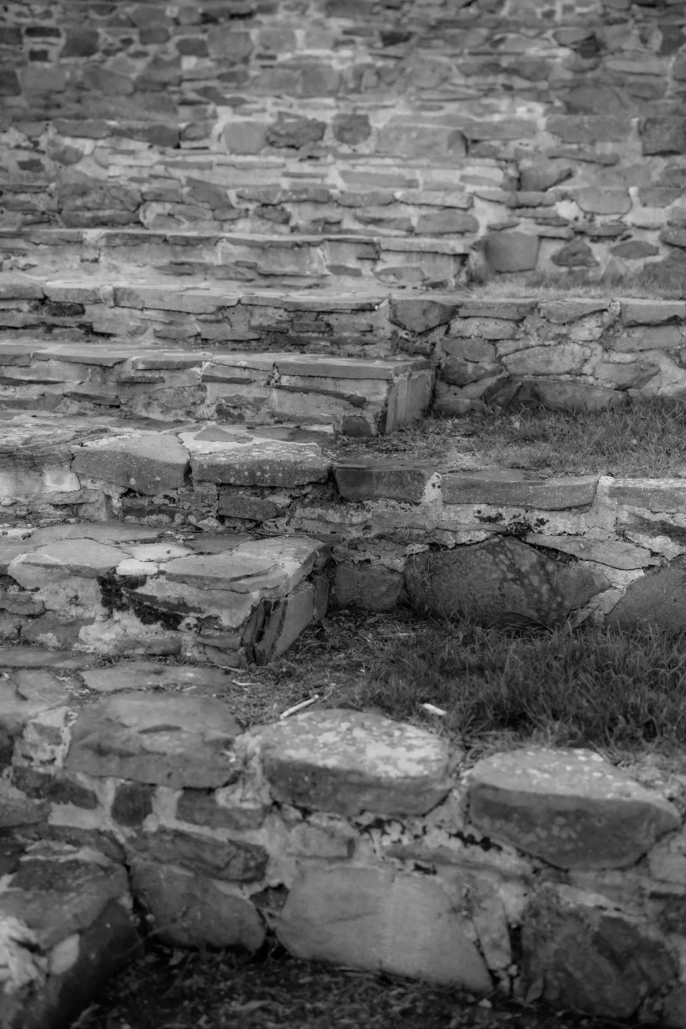 Black and white detail of the curved stone seating and grass terraces in Piermont’s amphitheatre. At Piermont Retreat on Tasmania’s east coast, for an Elopement Collective elopement. Photograph by Omar of By The Wilde.