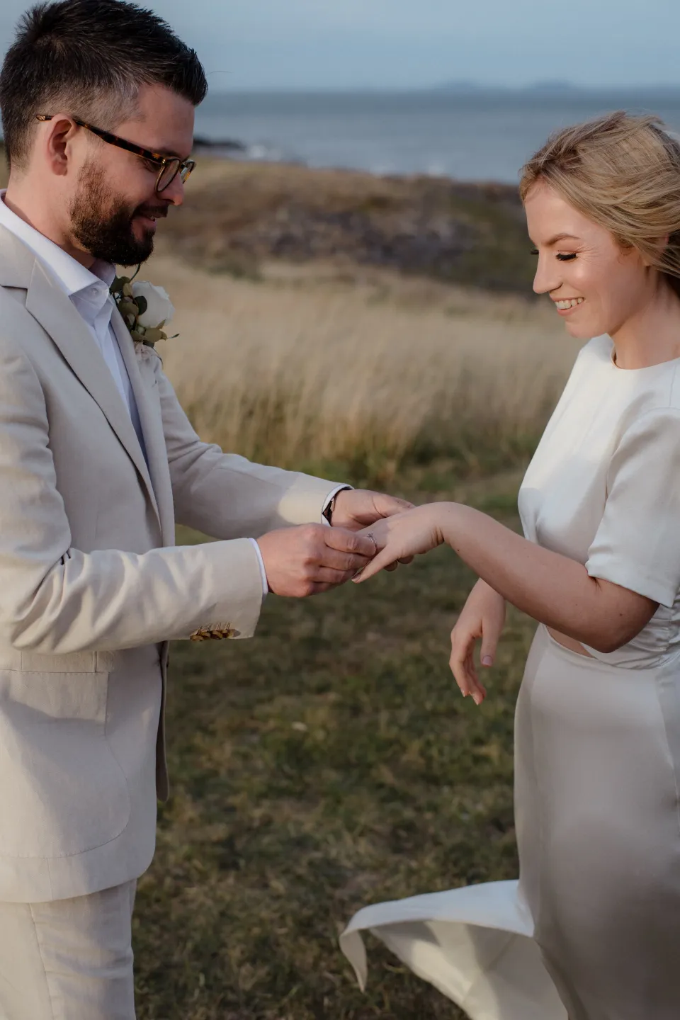 Jack placing a wedding ring on Jemmah’s hand, at Thalia Haven on the East Coast of Tasmania, Australia, for an Elopement Collective elopement. Photograph by Joey Willis.