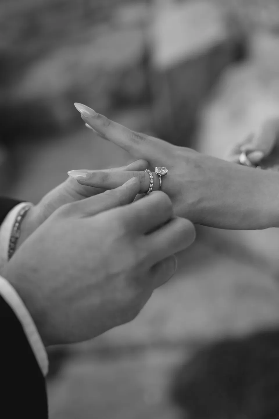 Black and white close-up of Harry placing a wedding band beside Clara’s engagement ring, at Thalia Haven on the East Coast of Tasmania, for an Elopement Collective elopement. Photograph by Bulb Creative.