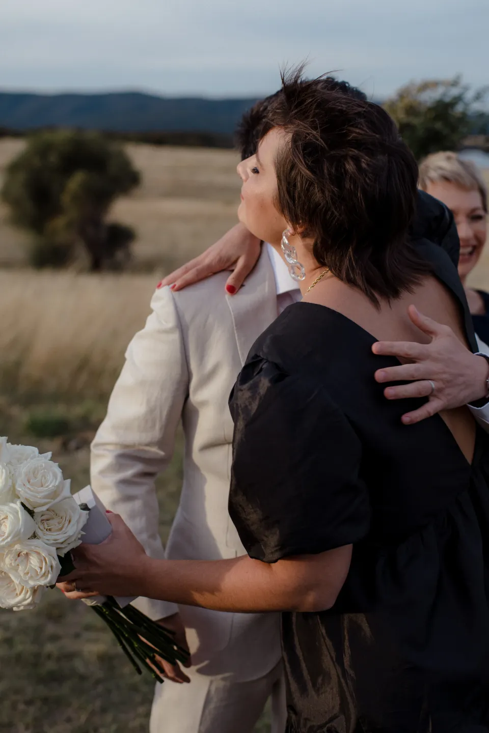 Guests and the couple exchanging hugs after the ceremony, at Thalia Haven on the East Coast of Tasmania, Australia, for an Elopement Collective elopement. Photograph by Joey Willis.