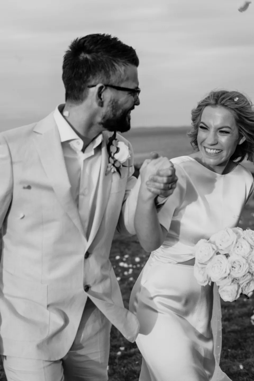 Black and white close portrait of the couple laughing together, at Thalia Haven on the East Coast of Tasmania, Australia, for an Elopement Collective elopement. Photograph by Joey Willis.