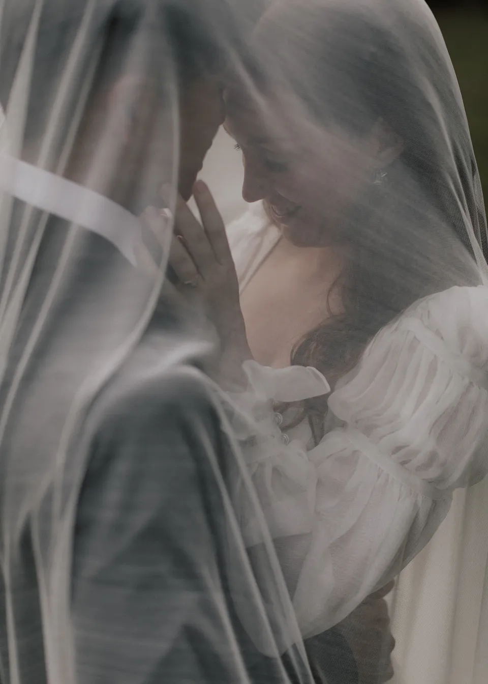 Close-up of the couple's faces beneath the soft folds of Elyse's veil. At Fig Tree Villa in Ewingsdale, Byron Bay, for an Elopement Collective elopement. Photograph by Bulb Creative.