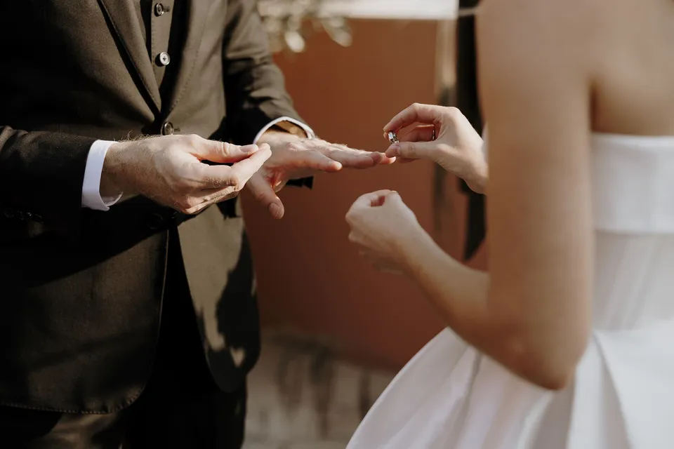 Close view of Danielle placing a wedding ring on Adam’s hand, during Danielle and Adam’s Elopement Collective elopement at The Calile Hotel in Fortitude Valley, Brisbane.