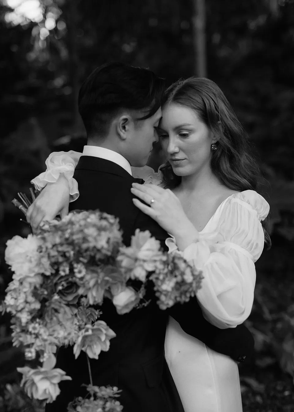Black-and-white close portrait of Elyse and Jonathan leaning their foreheads together. At Fig Tree Villa in Ewingsdale, Byron Bay, for an Elopement Collective elopement. Photograph by Bulb Creative.