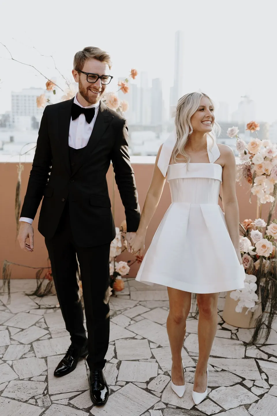 Danielle and Adam smiling and holding hands after their terrace ceremony, during Danielle and Adam’s Elopement Collective elopement at The Calile Hotel in Fortitude Valley, Brisbane.