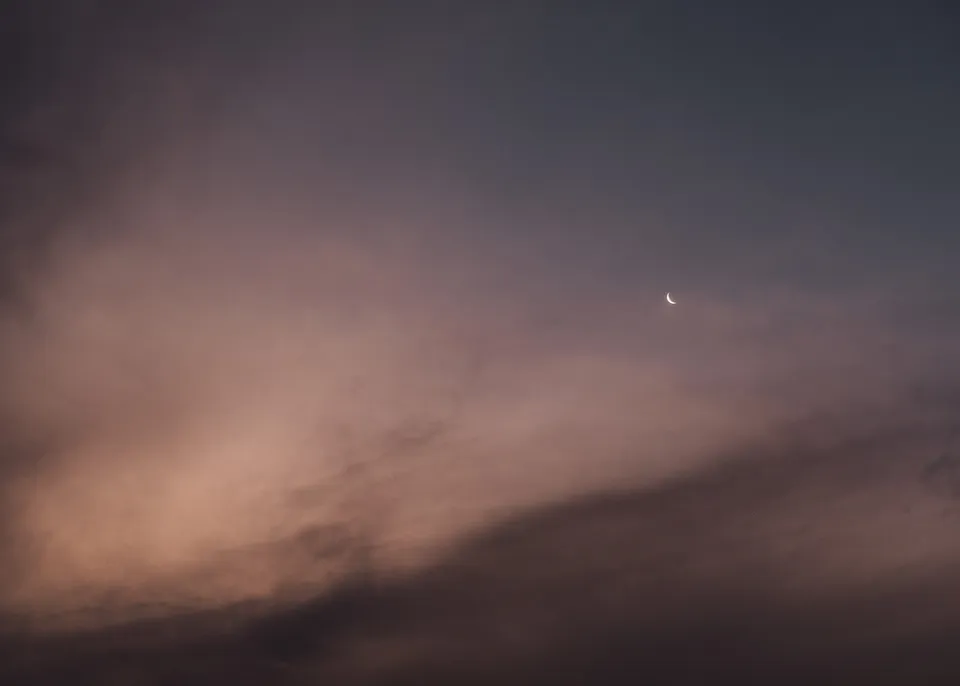 Wisps of pink cloud beneath a small moon at dusk. At Fig Tree Villa in Ewingsdale, Byron Bay, for an Elopement Collective elopement. Photograph by Bulb Creative.