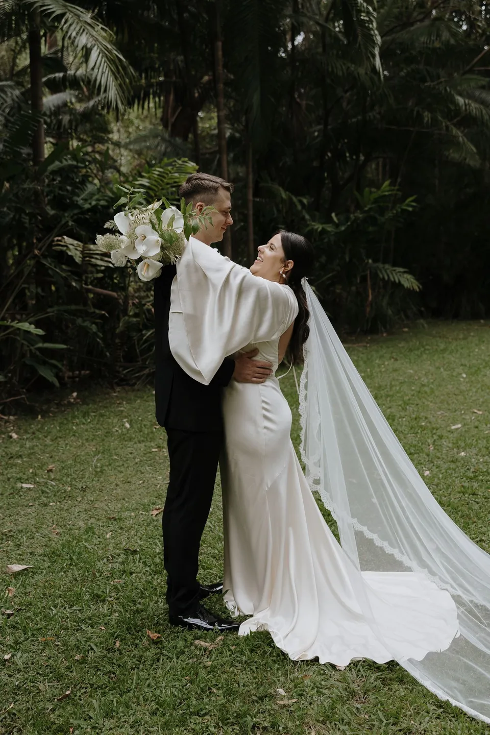 Matthew gently dipping Laura for a kiss in the garden. At Fig Tree Villa in Ewingsdale, Byron Bay, for an Elopement Collective elopement. Photograph by George Bowden.
