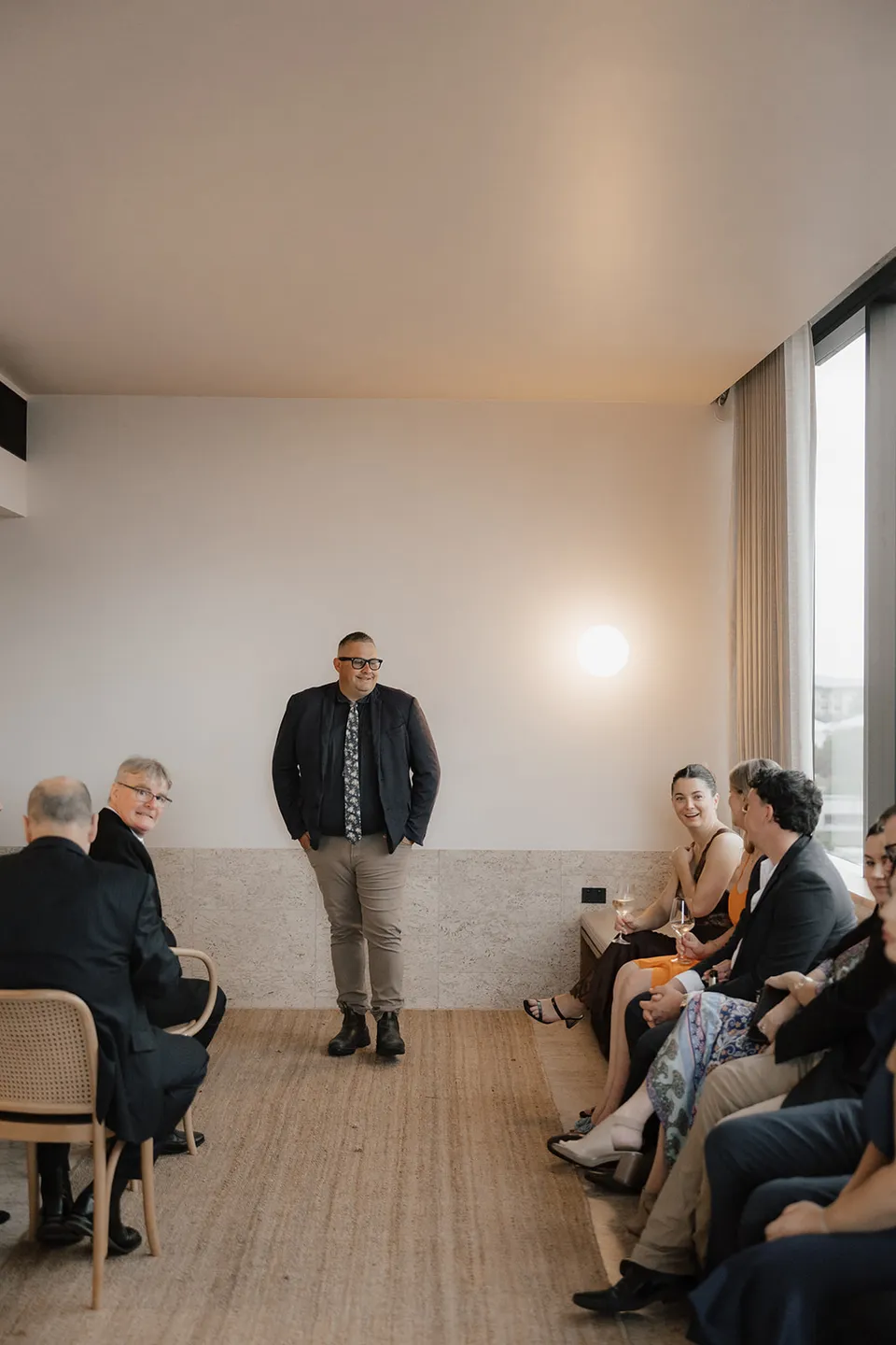 Josh Withers leading the ceremony with guests seated in the suite at The Calile Hotel, Fortitude Valley, for Clare and Matt’s Elopement Collective Brisbane elopement.