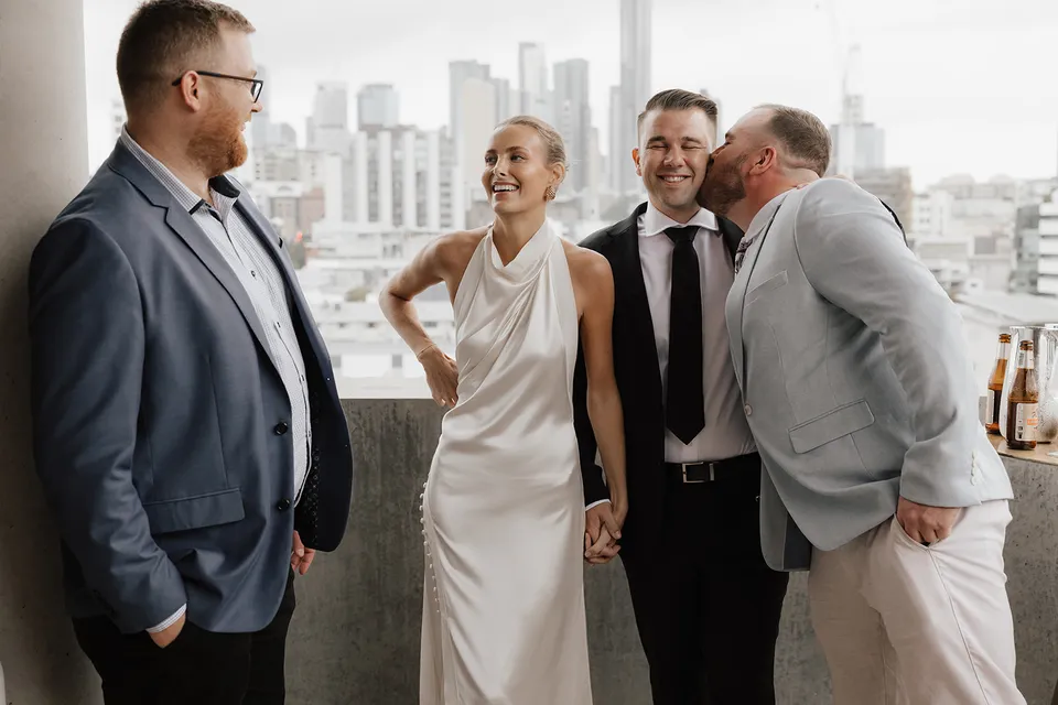 Clare and Matt smiling with guests on a terrace at The Calile Hotel, Fortitude Valley, after their Elopement Collective ceremony in Brisbane.
