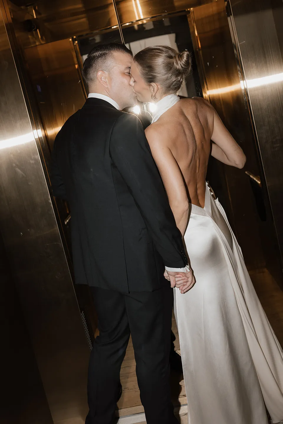Clare and Matt kissing in The Calile Hotel’s gold mirrored lift in Fortitude Valley during their Elopement Collective Brisbane elopement.