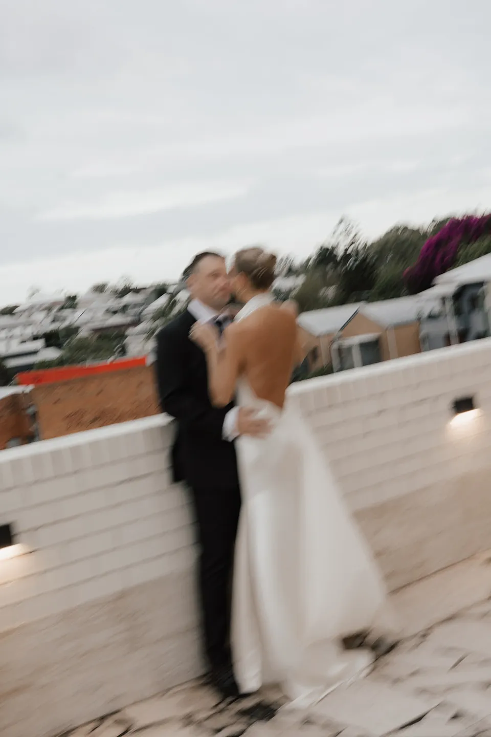 A softly blurred portrait of Clare and Matt embracing on The Calile Hotel terrace in Fortitude Valley during their Elopement Collective Brisbane elopement.