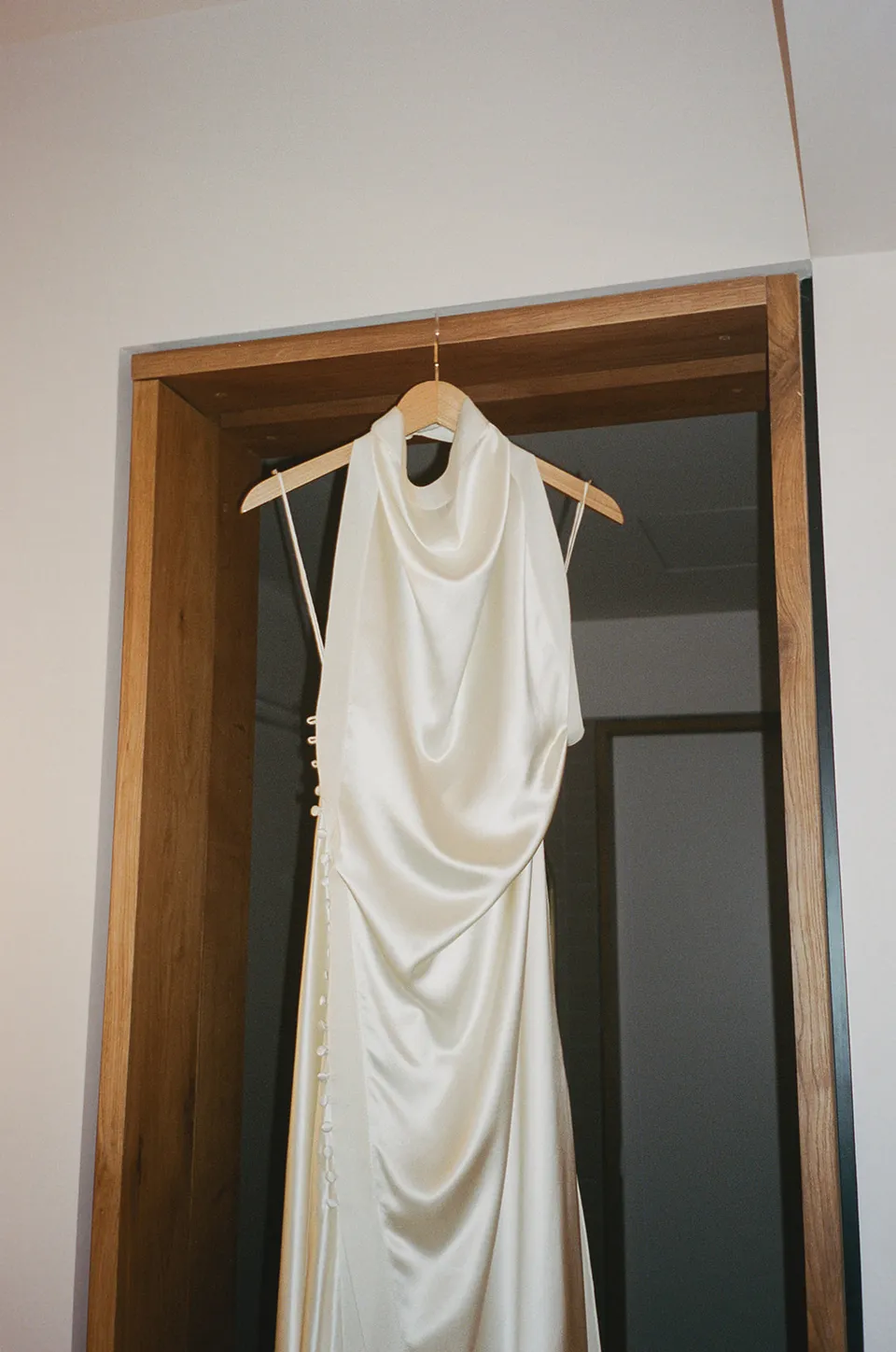 Clare’s draped ivory dress hanging in the suite at The Calile Hotel, Fortitude Valley, before her Elopement Collective elopement in Brisbane.