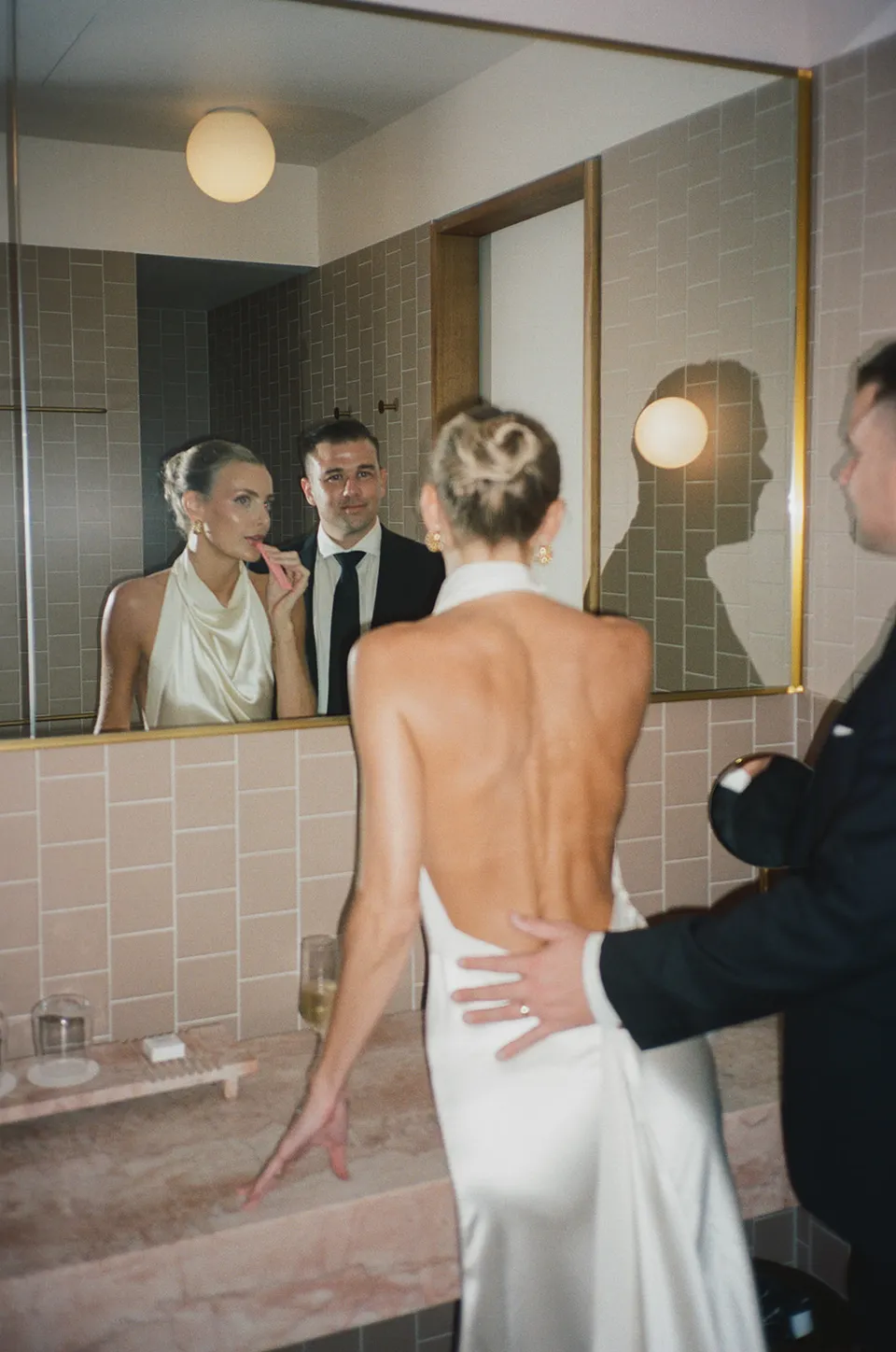 Clare and Matt reflected in their suite’s bathroom mirror at The Calile Hotel, Fortitude Valley, during their Elopement Collective Brisbane elopement.