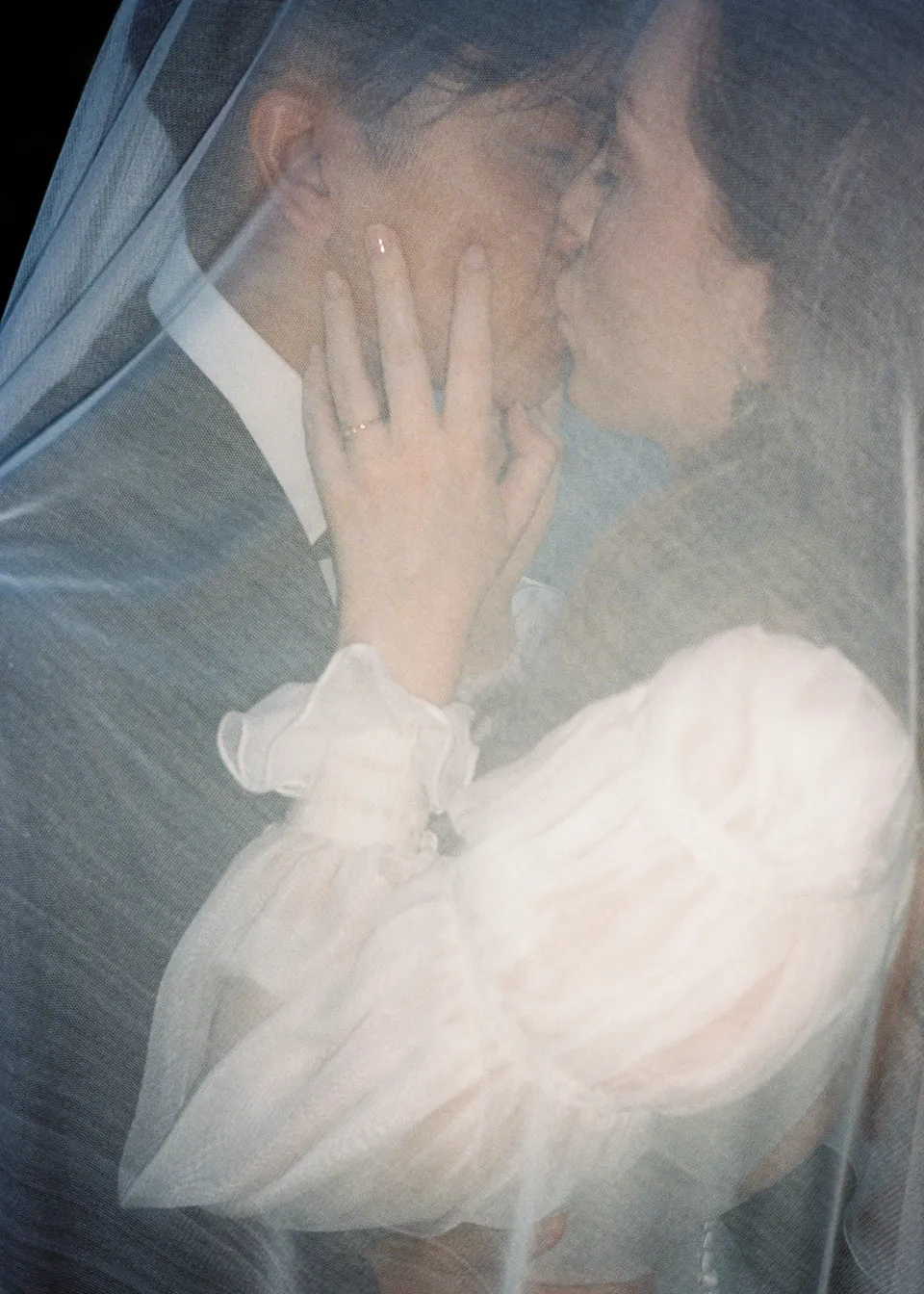 On 35mm film: Close-up of Elyse and Jonathan kissing beneath the translucent veil. At Fig Tree Villa in Ewingsdale, Byron Bay, for an Elopement Collective elopement. Photograph by Bulb Creative.