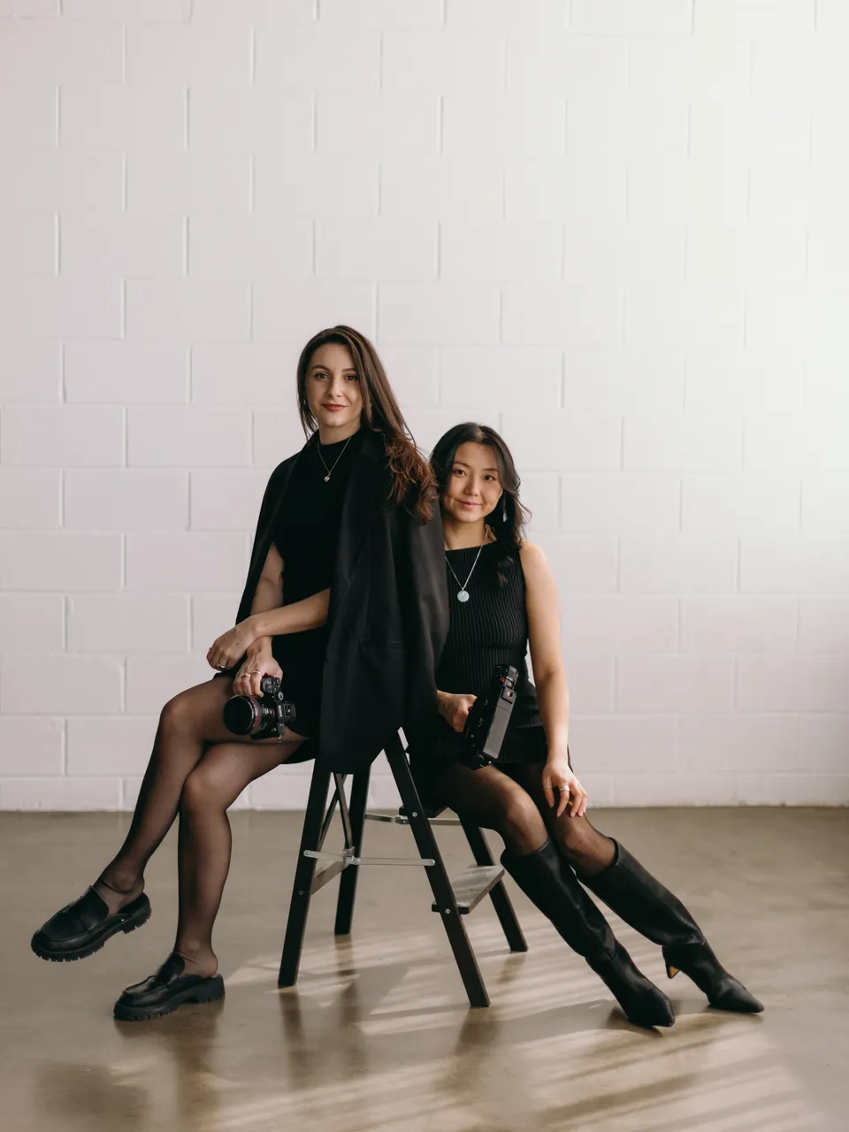 Leah and Christine of Golden Films, seated together with their cameras