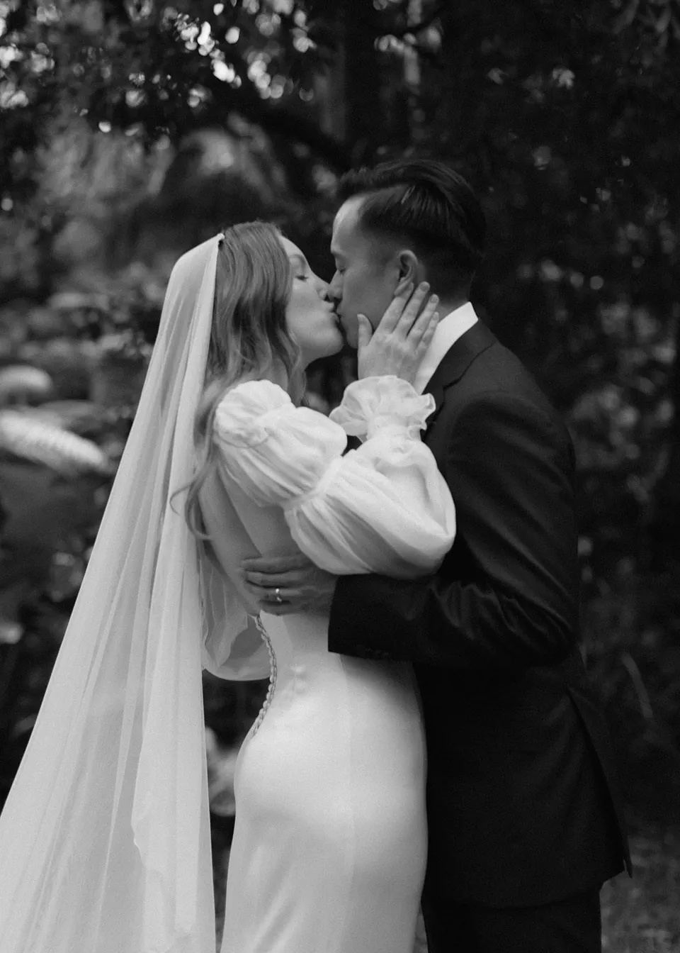 Black-and-white close portrait of the couple kissing after their vows. At Fig Tree Villa in Ewingsdale, Byron Bay, for an Elopement Collective elopement. Photograph by Bulb Creative.
