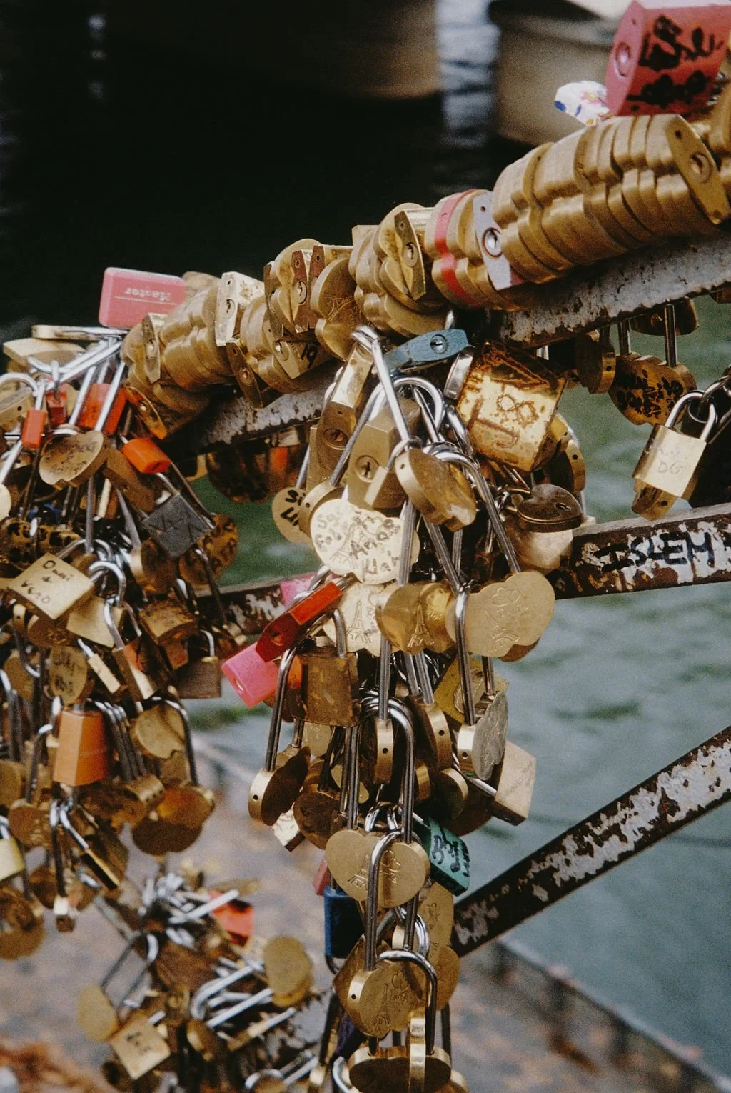 Love locks attached to a metal bridge railing.