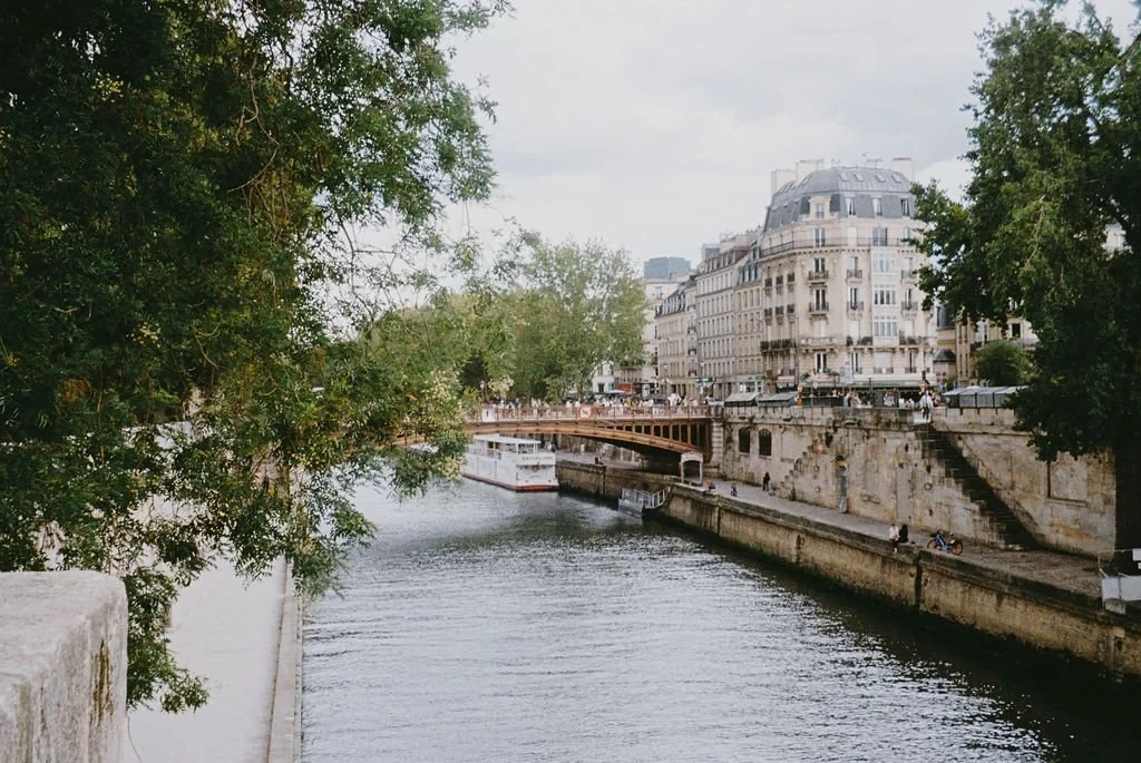 Scenic view of the Seine River in Paris with a boat and historic buildings.