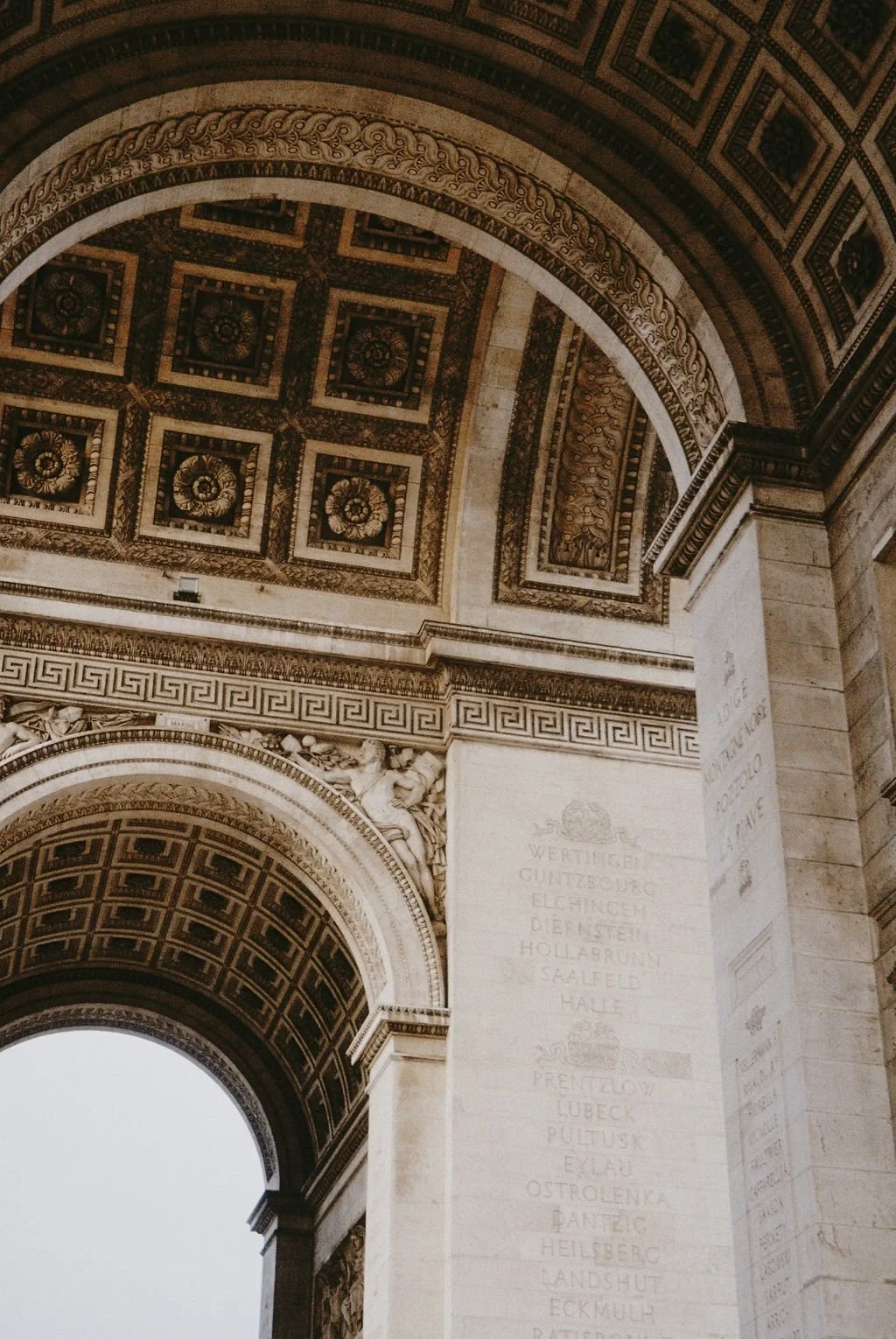 Interior view of decorative archway with intricate carvings and inscriptions on stone.