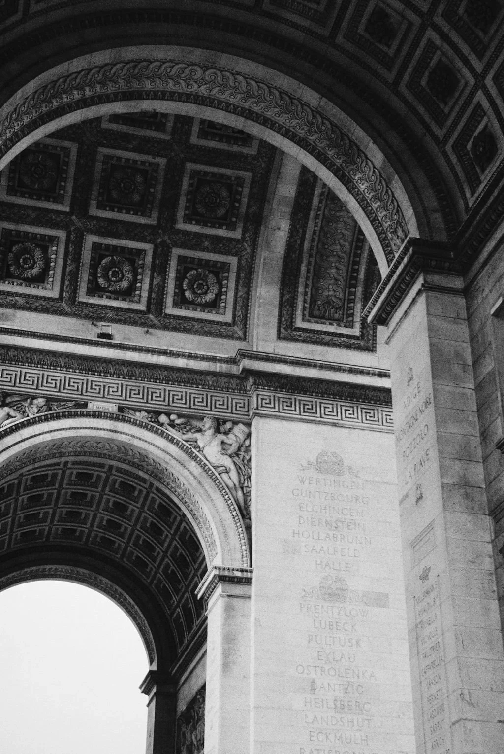 Architectural details of an archway, showing intricate carvings and inscriptions.