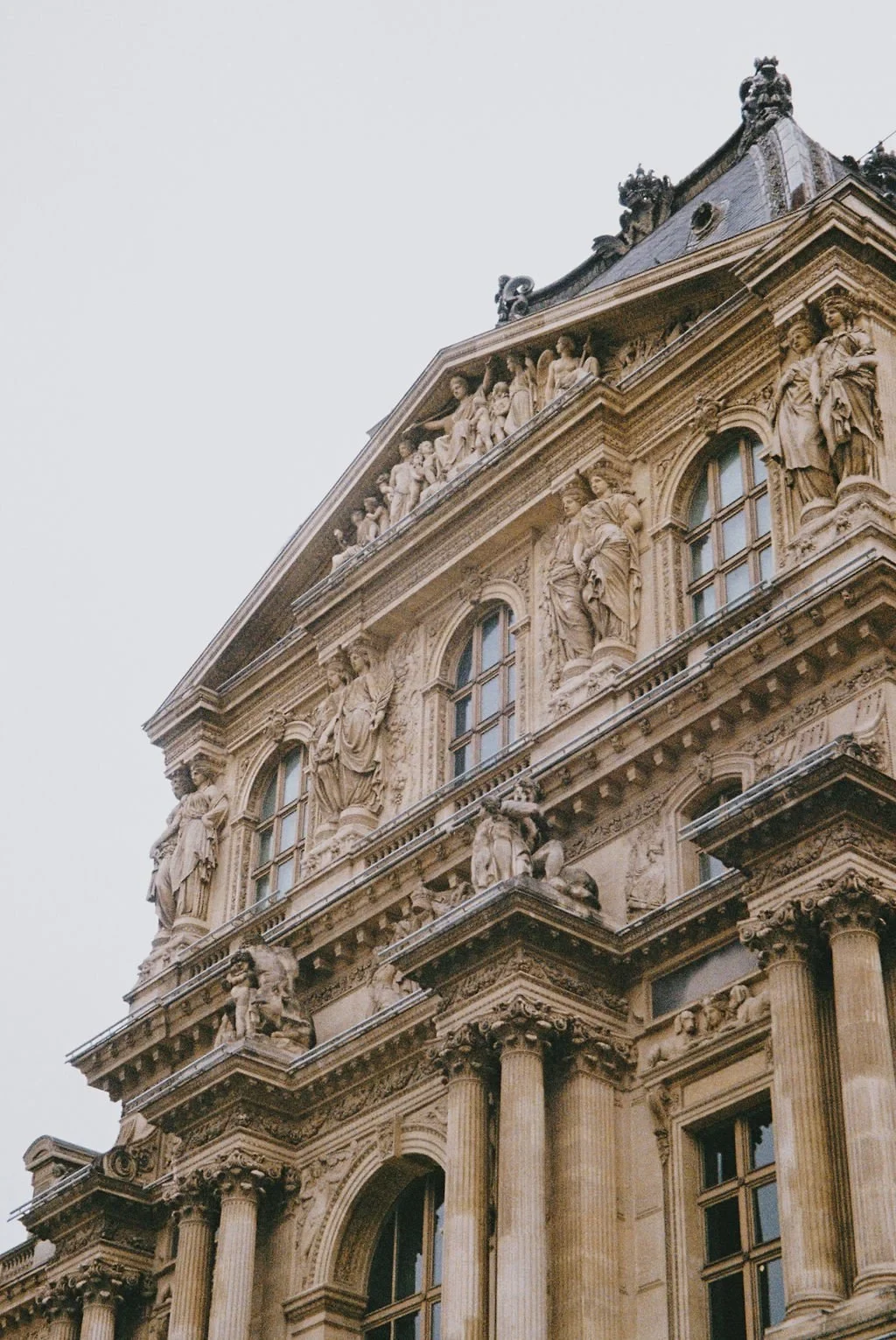 Ornate stone building facade with statues and columns.